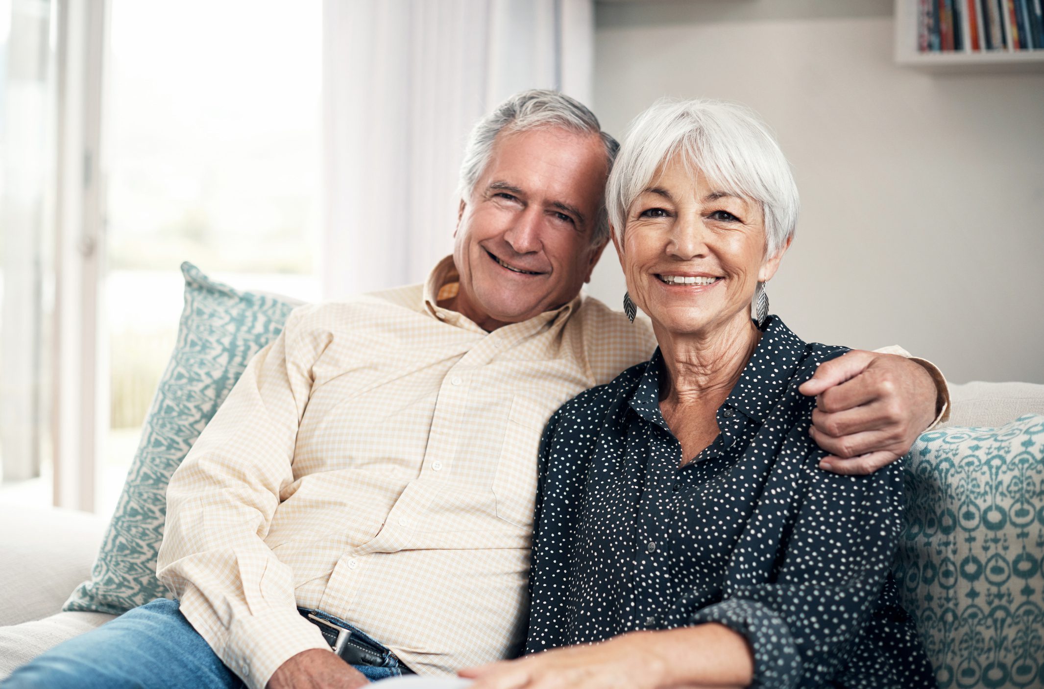 Home is where the heart is Senior couple at home relaxing together on sofa and smiling