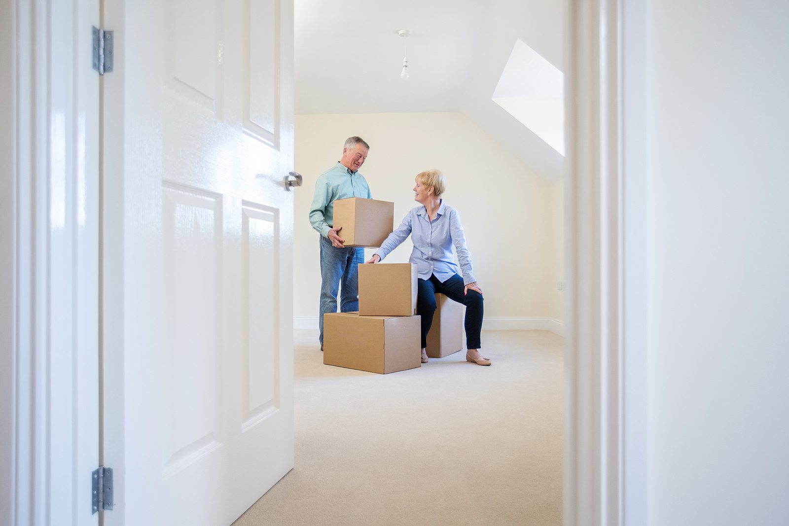 Senior Couple Downsizing In Retirement Carrying Boxes Into New H Senior couple packing boxes to downsize from family home